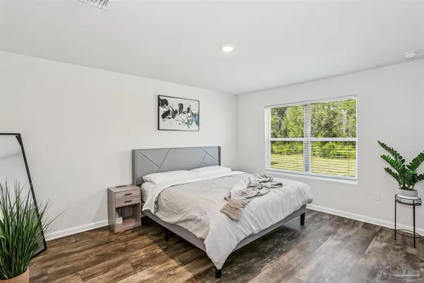 a bedroom with a large bed and a potted plant