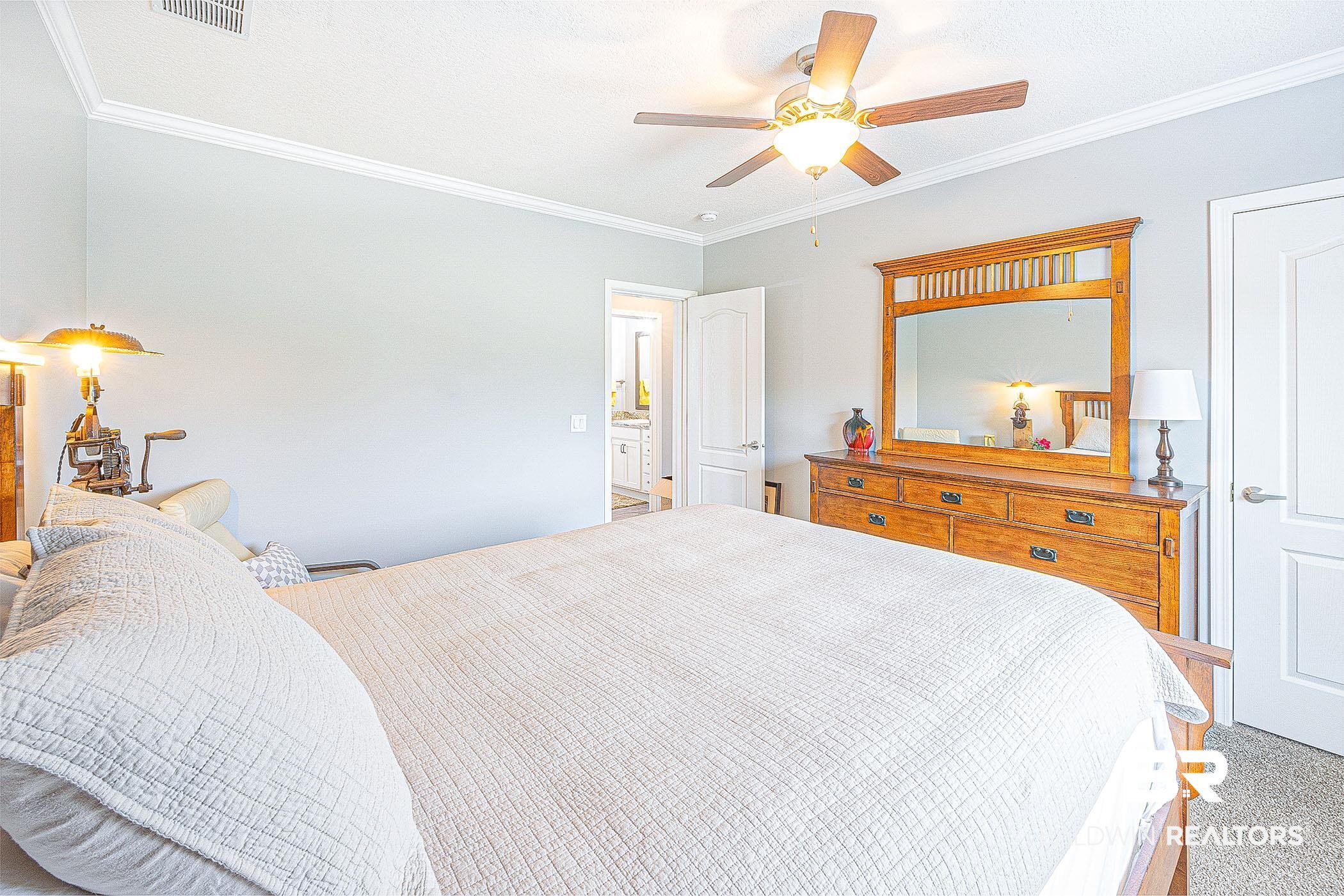16000 John Bauer Road Summerdale, AL 36580 - Photo 26 of 34 Bedroom with carpet, visible vents, ornamental molding, and a ceiling fan