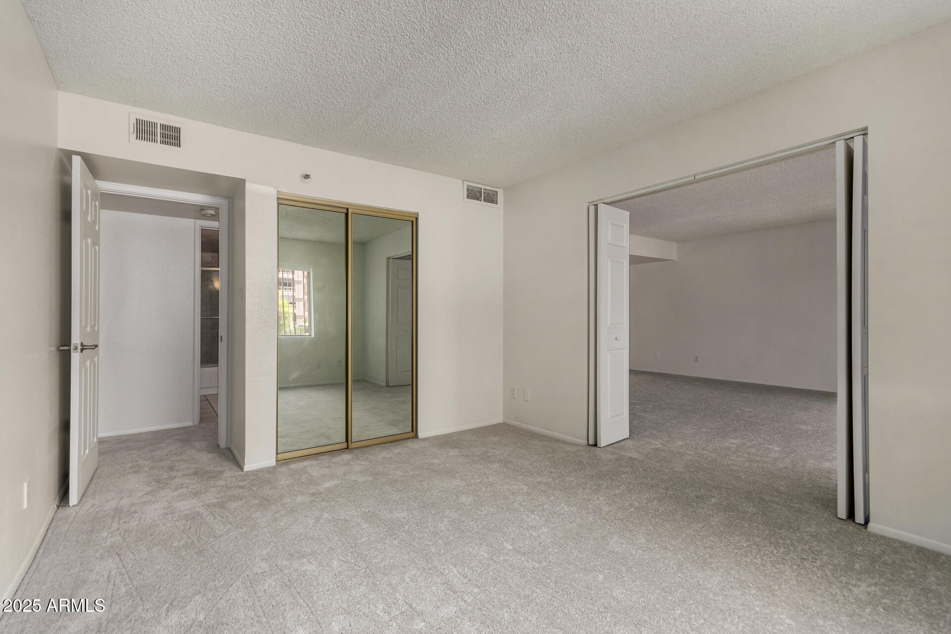 7850 East Camelback Road, Unit 101 Scottsdale, AZ 85251 - Photo 16 of 26 an empty room with closet and mirror