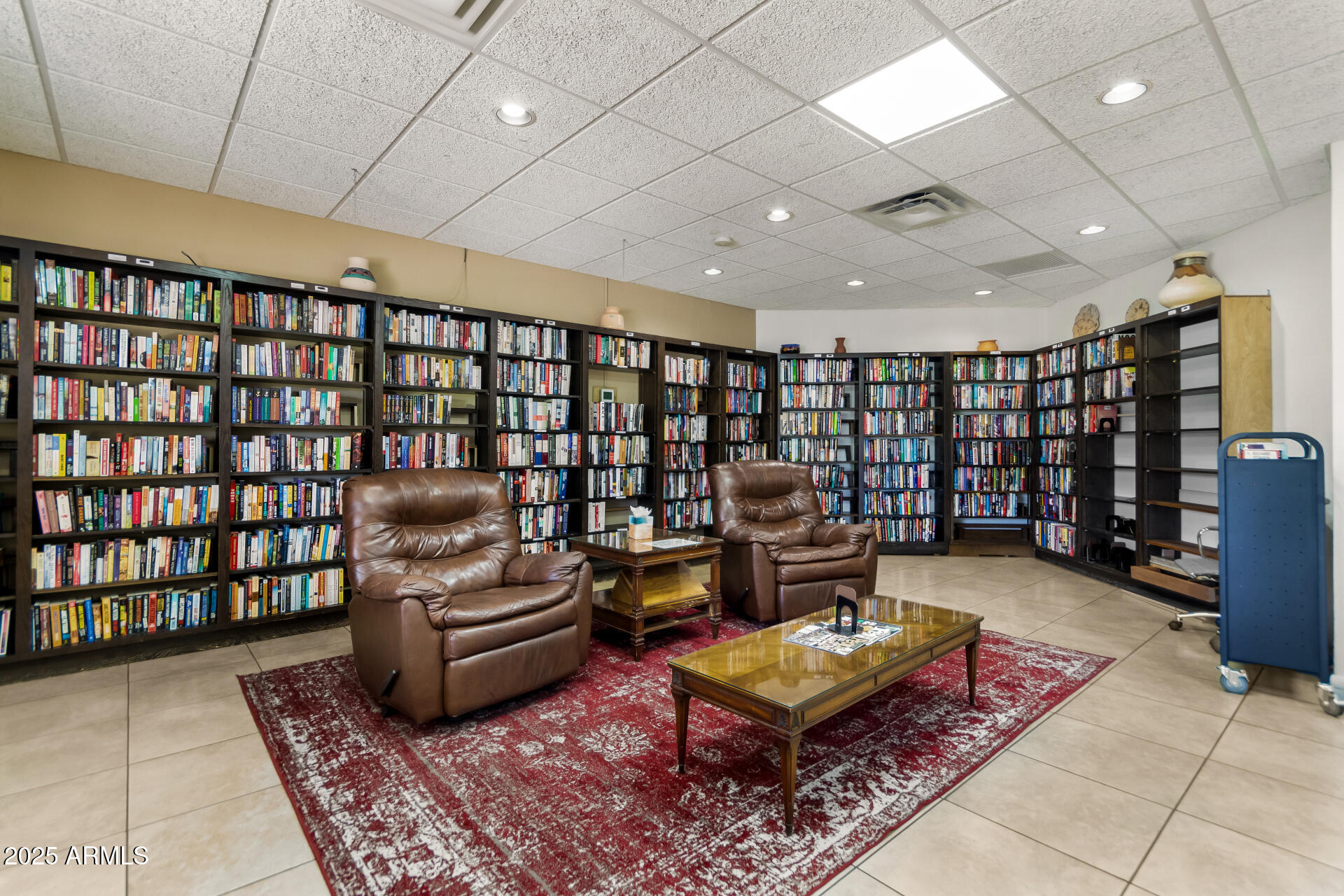 7850 East Camelback Road, Unit 101 Scottsdale, AZ 85251 - Photo 22 of 26 a living room with furniture a rug and a book shelf