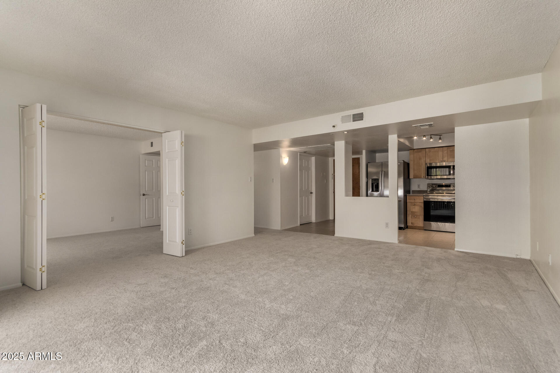 7850 East Camelback Road, Unit 101 Scottsdale, AZ 85251 - Photo 6 of 26 a view of an empty room with a kitchen