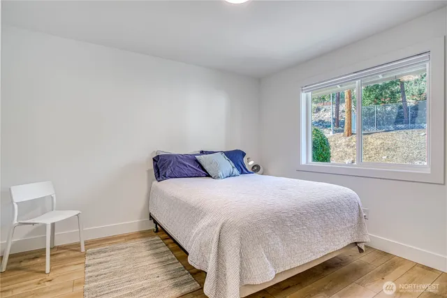 a large bed sitting in a bedroom next to a window