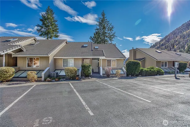 a front view of a house with yard and trees in the background