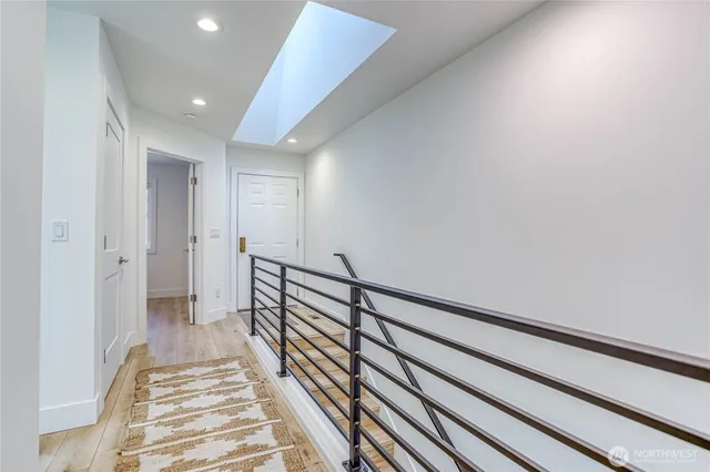a view of a hallway with wooden floor and staircase