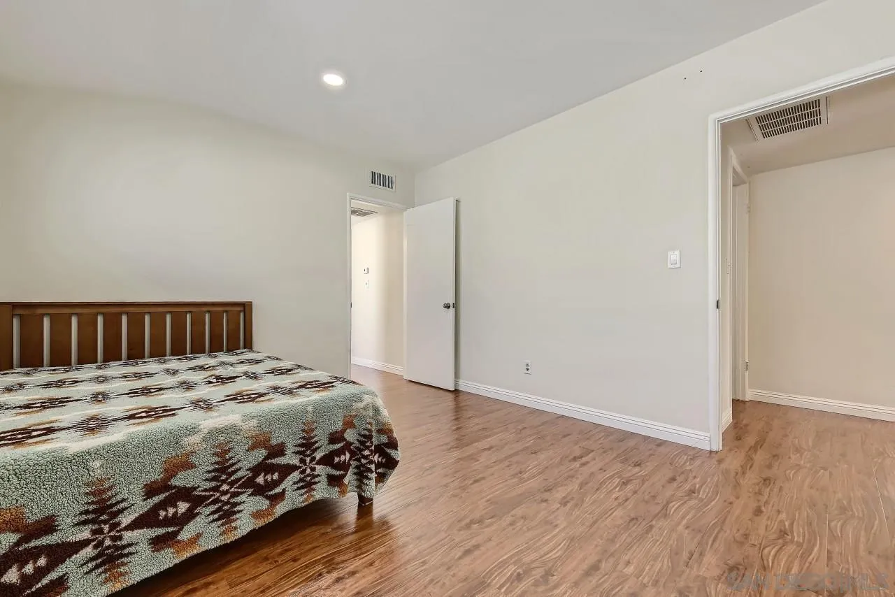 13847 Tobiasson Road Poway, CA 92064 - Photo 15 of 28 a bedroom with a bed and wooden floor