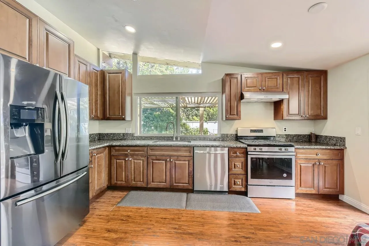 13847 Tobiasson Road Poway, CA 92064 - Photo 7 of 28 a kitchen with stainless steel appliances granite countertop a stove a sink and a refrigerator