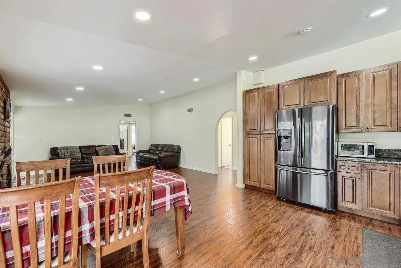 13847 Tobiasson Road Poway, CA 92064 - Photo 8 of 28 a kitchen with stainless steel appliances granite countertop a refrigerator and a dining table