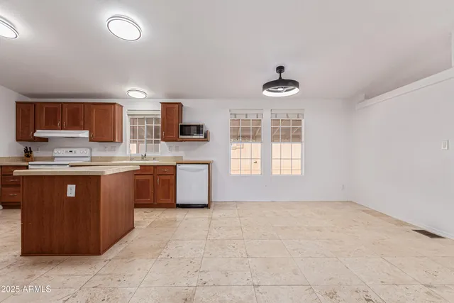 a kitchen with stainless steel appliances granite countertop a stove a sink dishwasher and a refrigerator