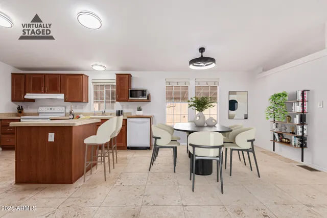 a dining room with stainless steel appliances a table and chairs in it