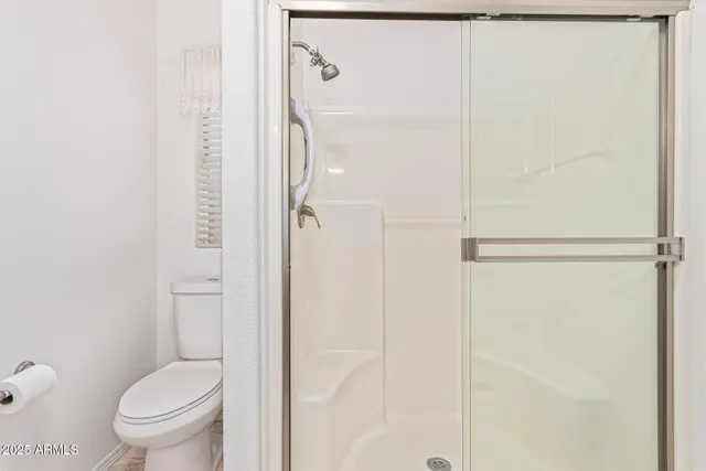 a bathroom with a granite countertop toilet and a shower