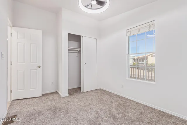 an empty room with windows and closet