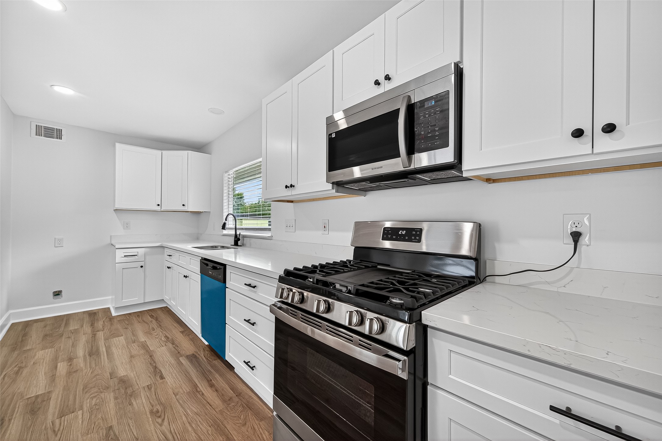 1609 North Pacific Street Conroe, TX 77301 - Photo 11 of 28 a kitchen with cabinets stainless steel appliances and wooden floor