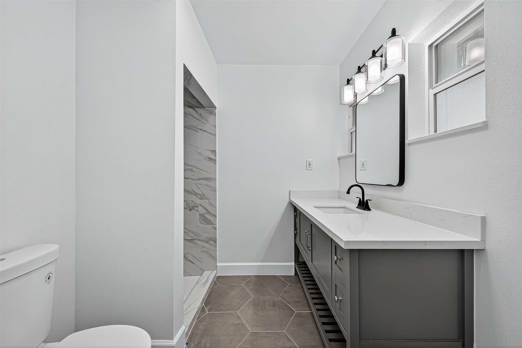 1609 North Pacific Street Conroe, TX 77301 - Photo 16 of 28 a bathroom with a sink a toilet and mirror