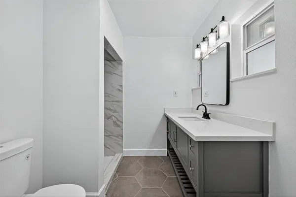 a bathroom with a sink a toilet and mirror