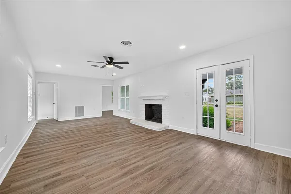 a view of an empty room with a fireplace and a window