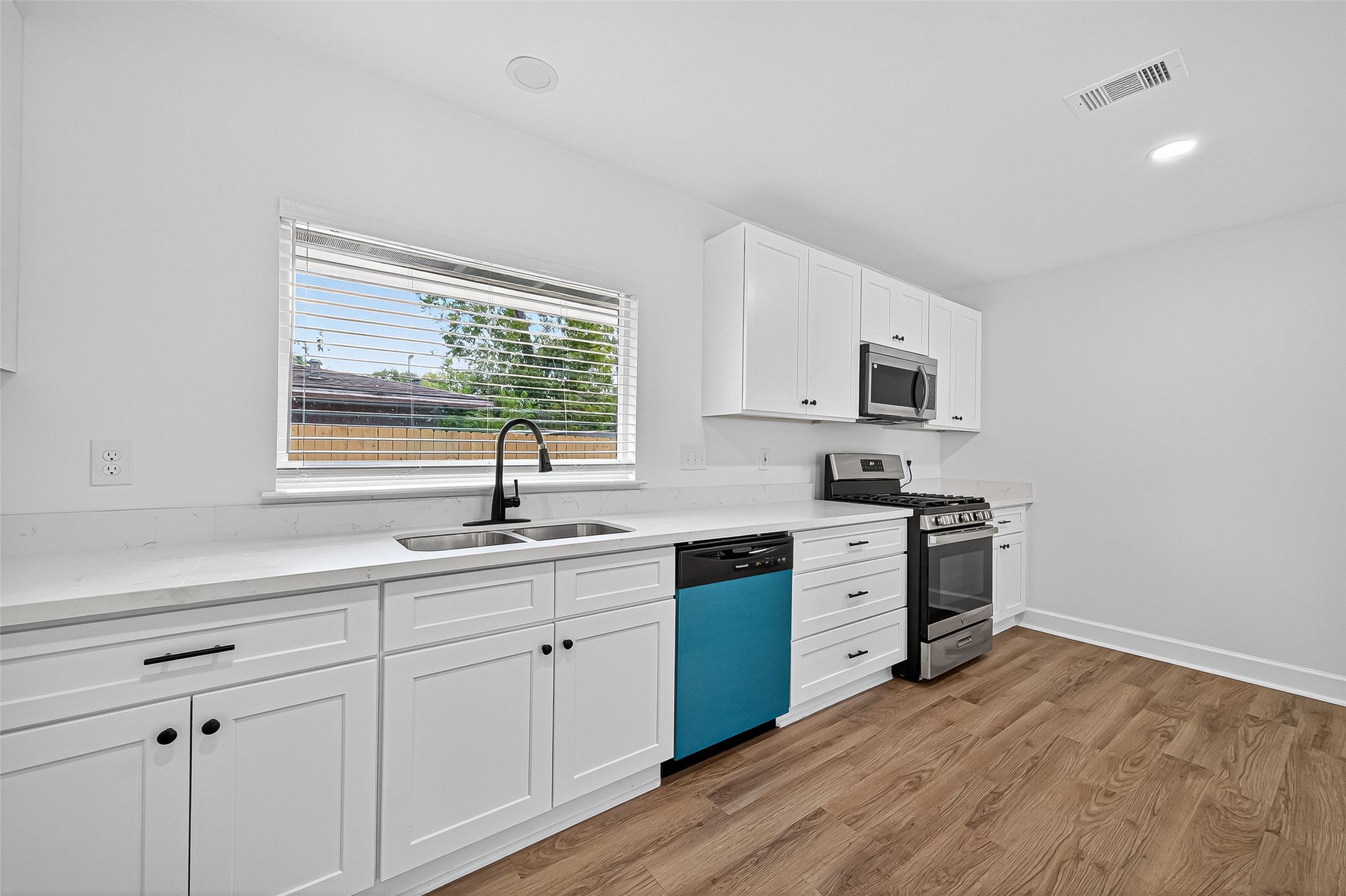 1609 North Pacific Street Conroe, TX 77301 - Photo 8 of 28 a kitchen with white cabinets and a sink