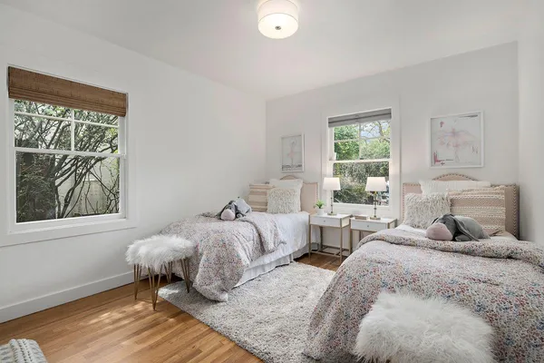 a bedroom with two beds and a window