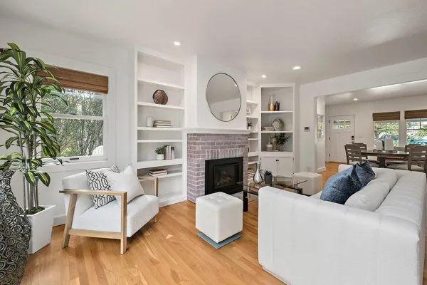 a living room with furniture fireplace and a large window