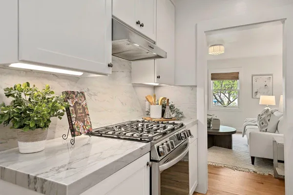 a kitchen with a stove and a white cabinets