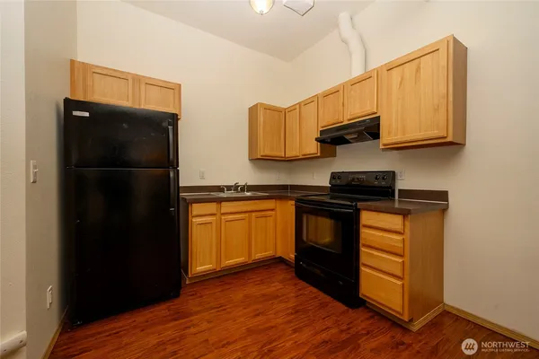 a kitchen with a refrigerator and a stove top oven