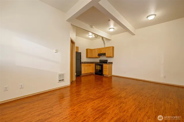 a view of an empty room with wooden floor