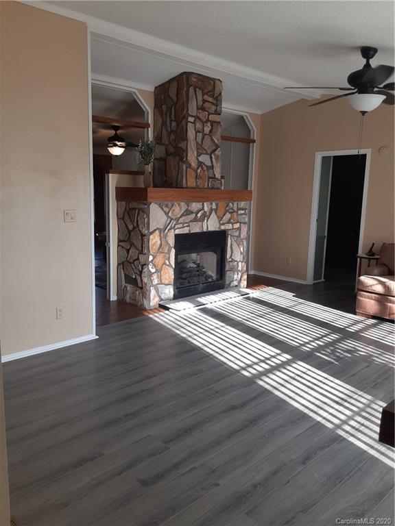 511 Daniels Ridge Road Taylorsville, NC 28681 - Photo 22 of 28 a view of an empty room with wooden floor fireplace and a window