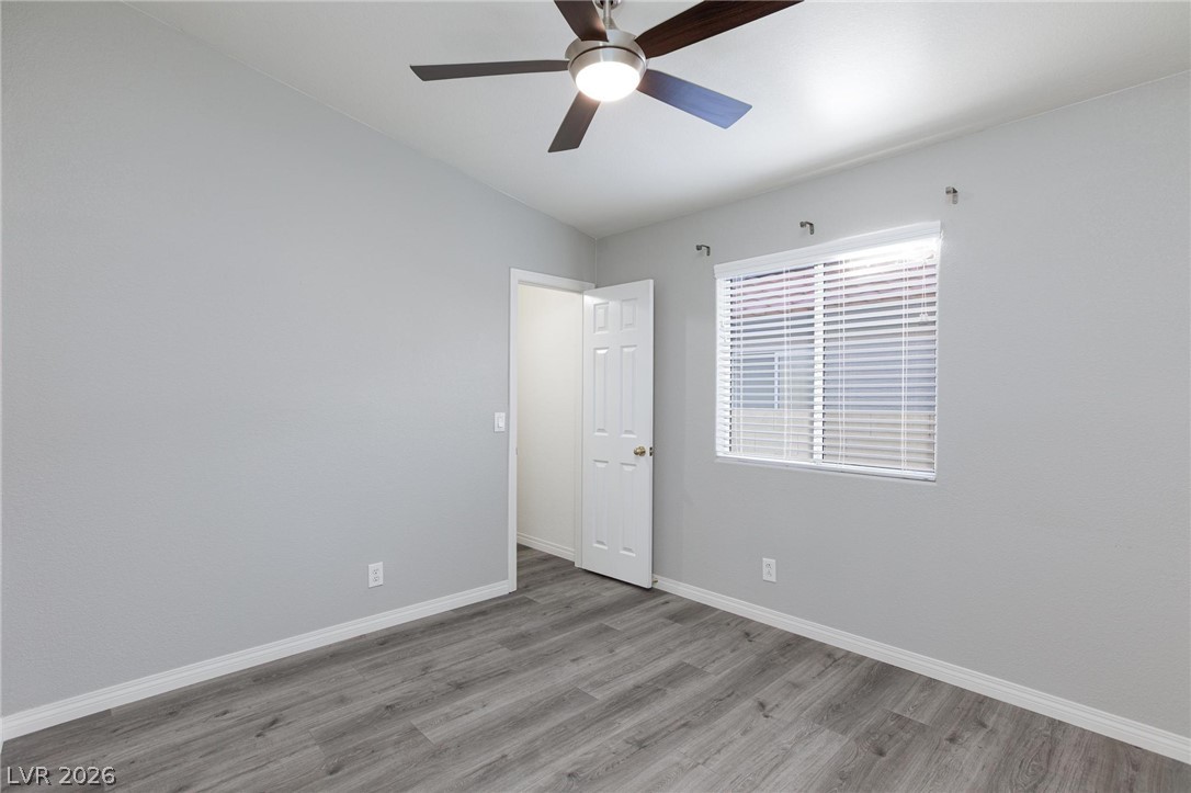 2254 Ramsgate Drive Henderson, NV 89074 - Photo 27 of 43 A well-lit bedroom features durable plank flooring and a modern ceiling fan for comfort.