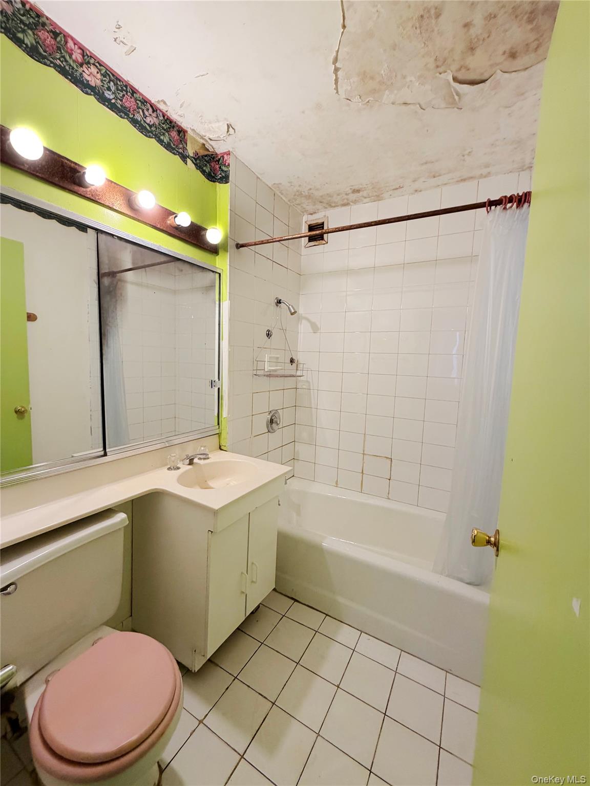 520 West 112th Street, Unit 4B Manhattan, NY 10025 - Photo 9 of 11 Bathroom featuring vanity, shower / bath combo with shower curtain, and light tile patterned floors