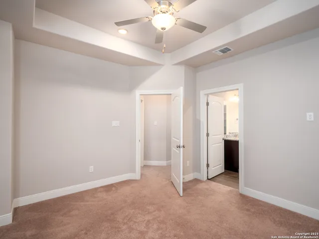 an empty room with fan and entrance