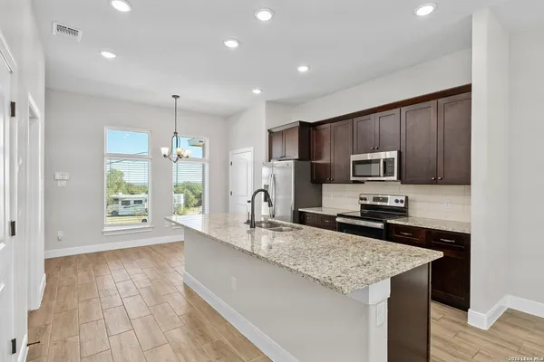 a kitchen with stainless steel appliances granite countertop a sink stove and refrigerator