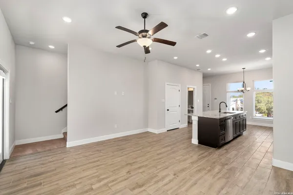 a living room with hard wood flooring and a ceiling fan