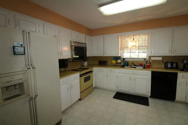 a kitchen with stainless steel appliances granite countertop a sink a stove and cabinets