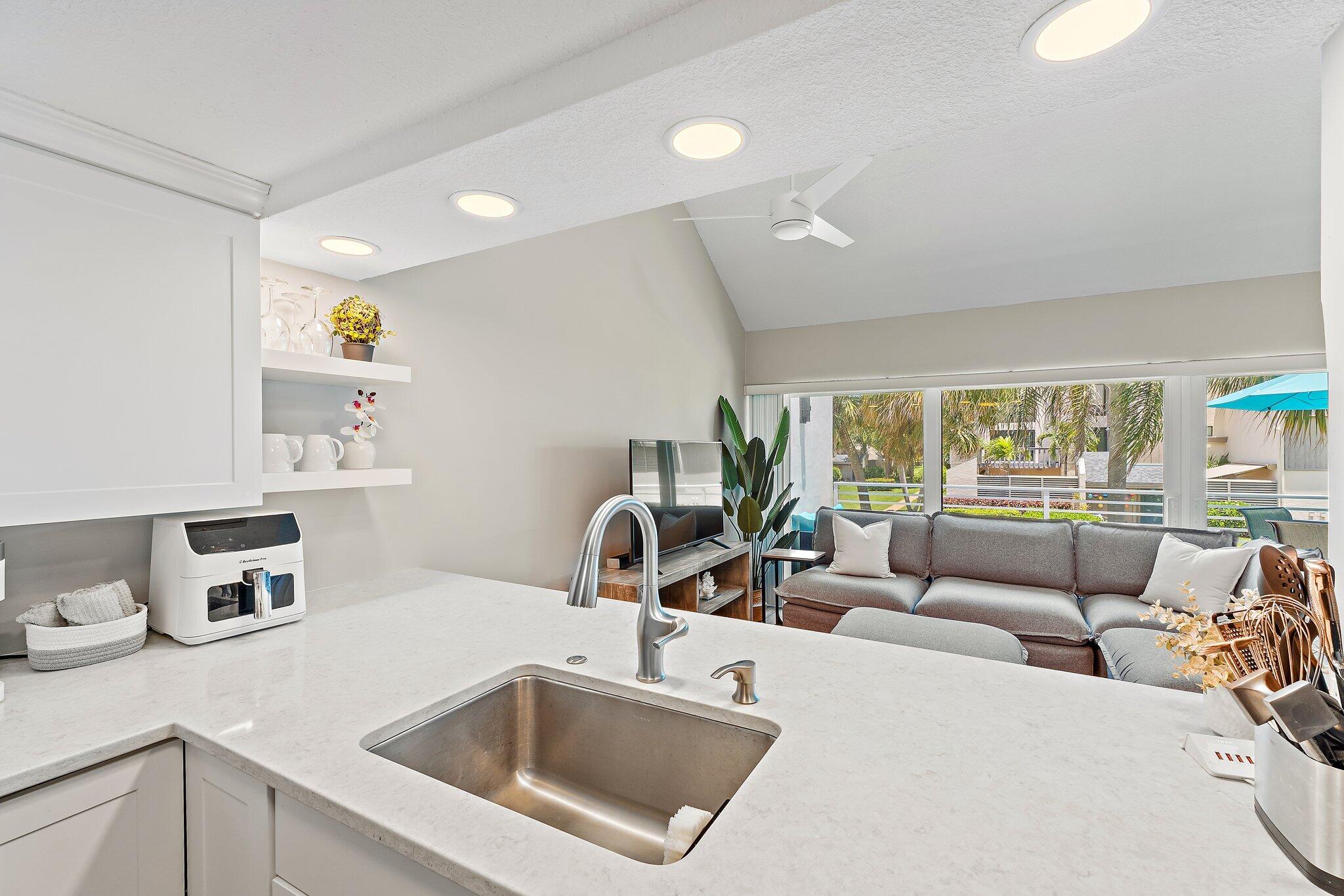 1605 Highway 1, Unit 209M2 Jupiter, FL 33477 - Photo 12 of 26 a kitchen with stainless steel appliances a sink a stove a refrigerator a counter top oven and couches