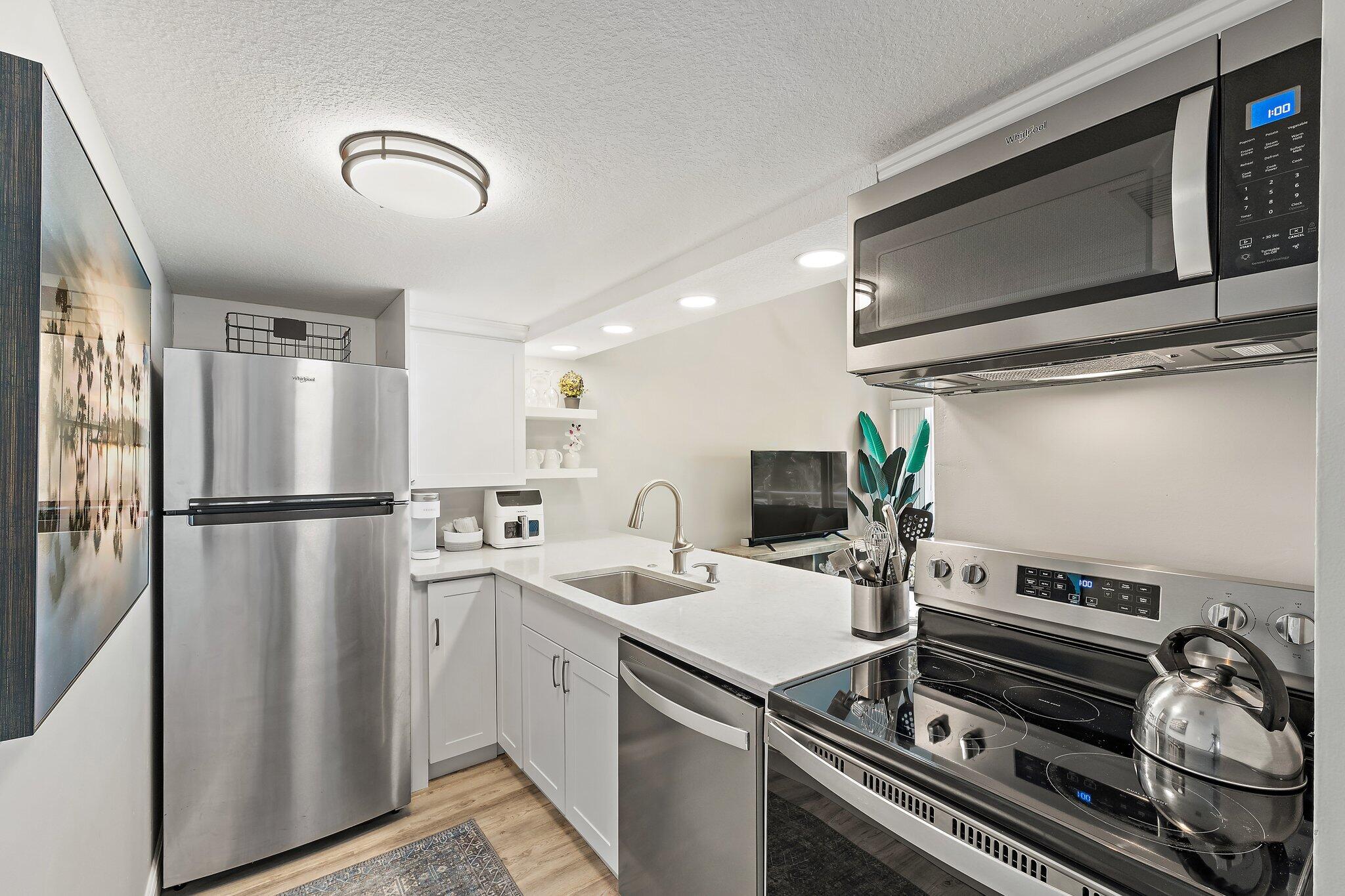 1605 Highway 1, Unit 209M2 Jupiter, FL 33477 - Photo 10 of 26 a kitchen with a refrigerator and a stove