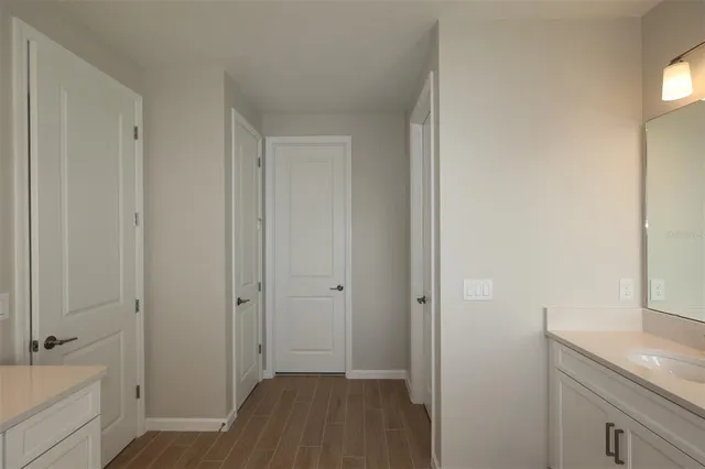 a view of bathroom with a sink mirror and window