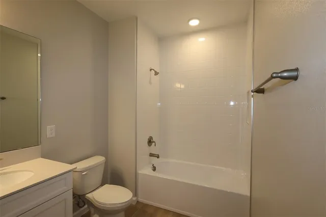 a bathroom with a granite countertop toilet a sink and shower