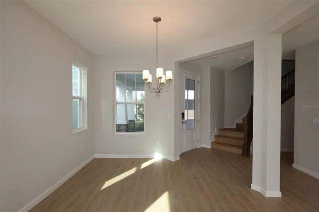 a view of a hallway with wooden floor and stairs