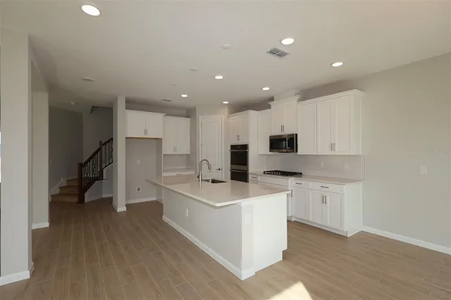a large white kitchen with stainless steel appliances