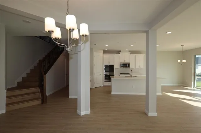 a view of a livingroom with dining area wooden floor and kitchen view