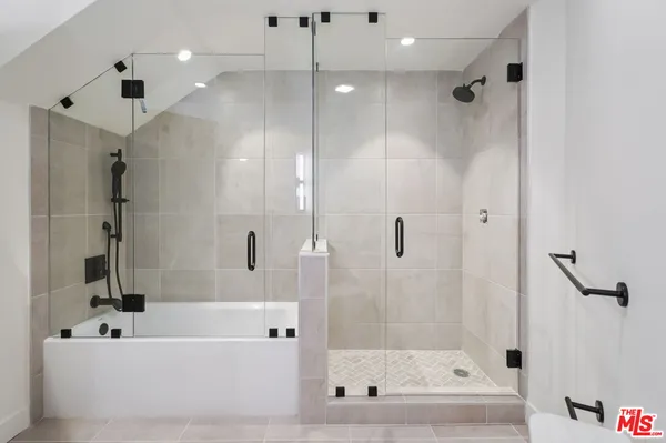 a bathroom with a bathtub a shower and a shower