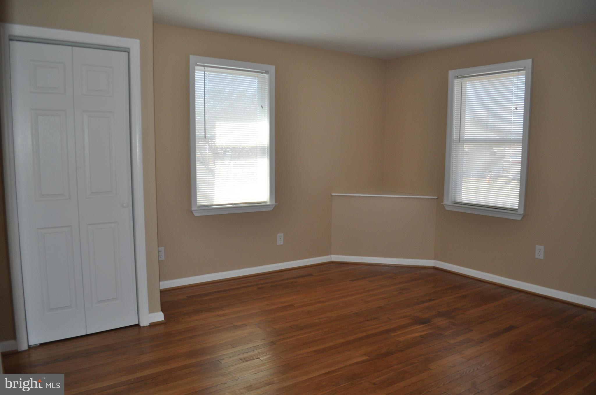 929 Woodlynn Road Baltimore, MD 21221 - Photo 11 of 25 an empty room with wooden floor and windows