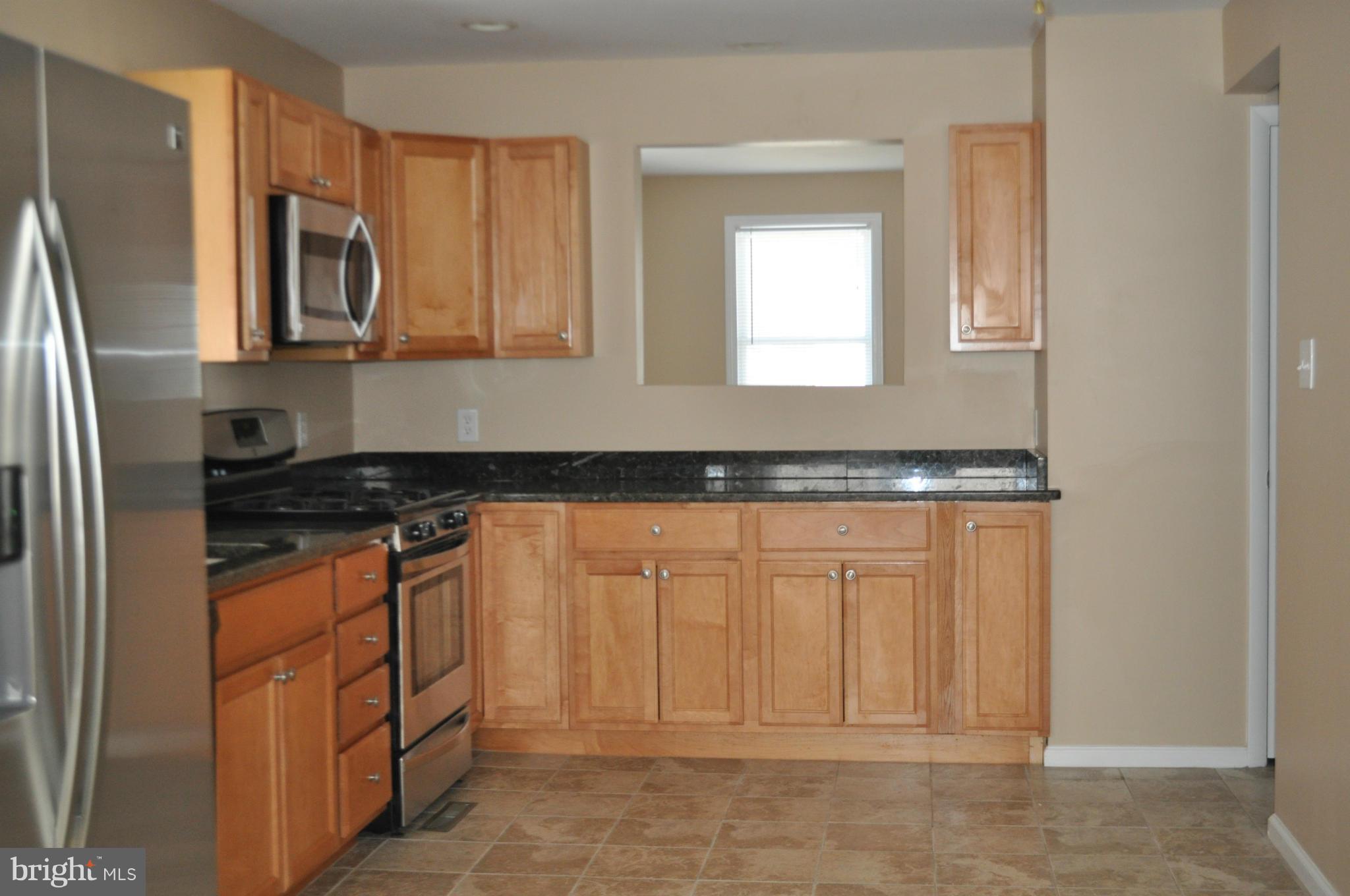 929 Woodlynn Road Baltimore, MD 21221 - Photo 3 of 25 a kitchen with stainless steel appliances granite countertop a refrigerator and a stove