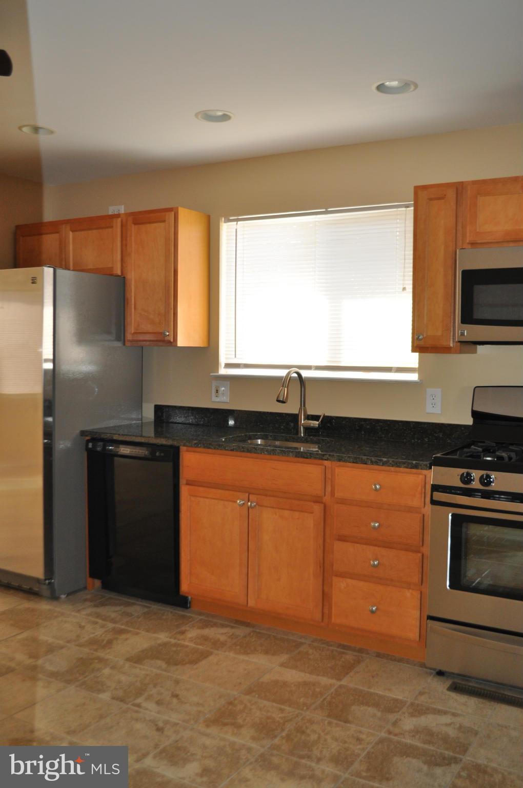 929 Woodlynn Road Baltimore, MD 21221 - Photo 5 of 25 a kitchen with stainless steel appliances granite countertop a stove a sink and a microwave