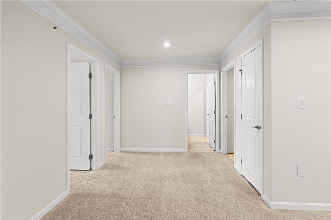 4758 Rafi Road Easton, PA 18045 - Photo 34 of 55 A well-lit, neutral-toned room features crown molding and plush carpeting, offering a clean, inviting space.