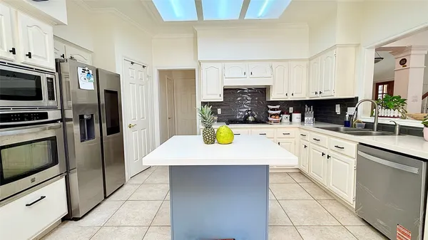 a kitchen with stainless steel appliances a sink a stove top oven a counter space and cabinets