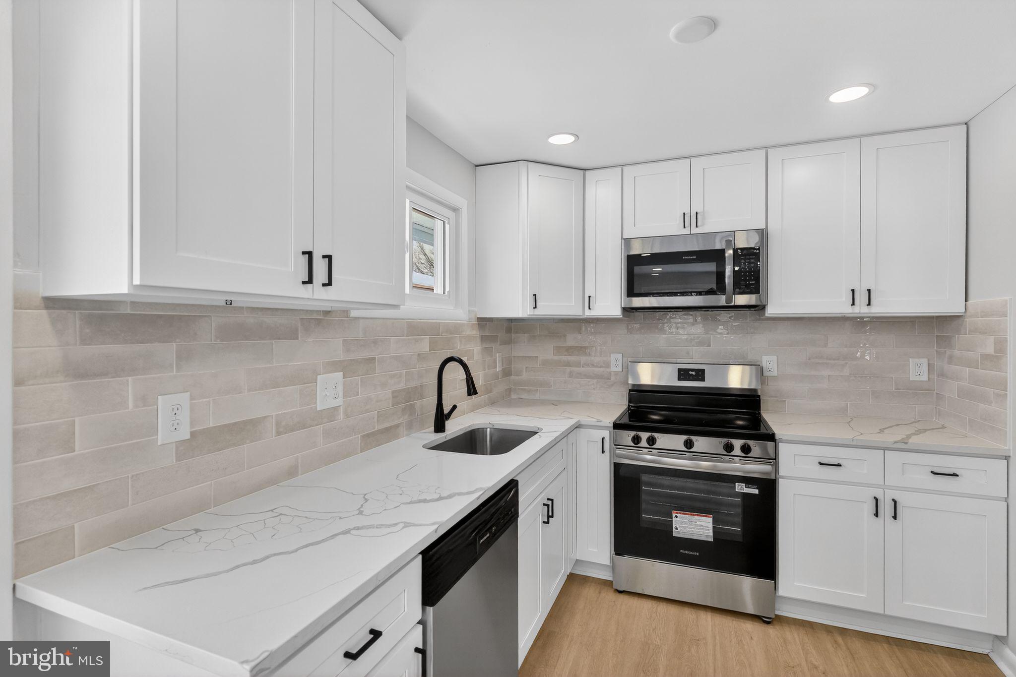 203 Antietam Road Baltimore, MD 21221 - Photo 11 of 33 a kitchen with cabinets appliances a sink and a counter top