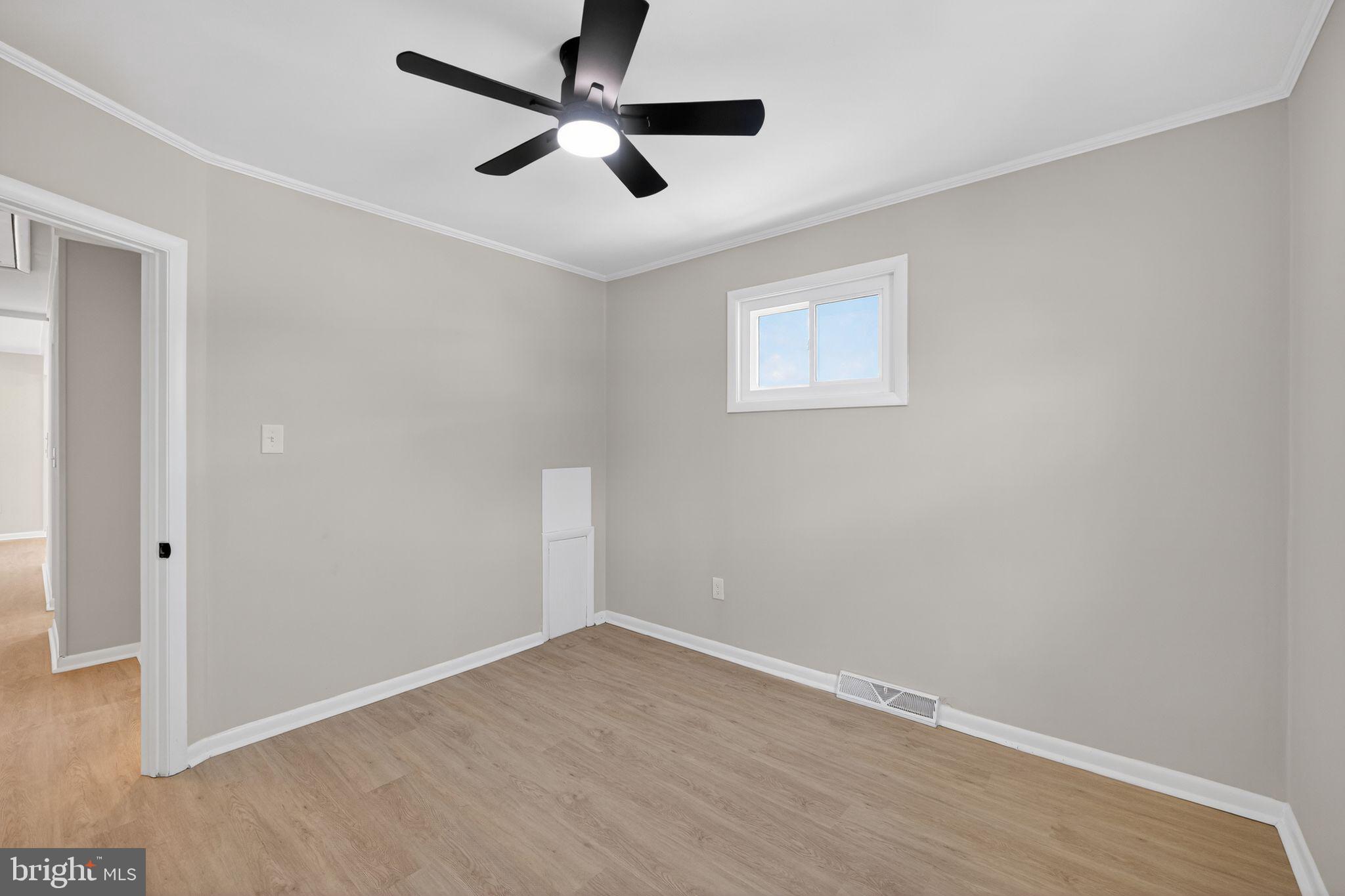 203 Antietam Road Baltimore, MD 21221 - Photo 24 of 33 an empty room with wooden floor ceiling fan and window