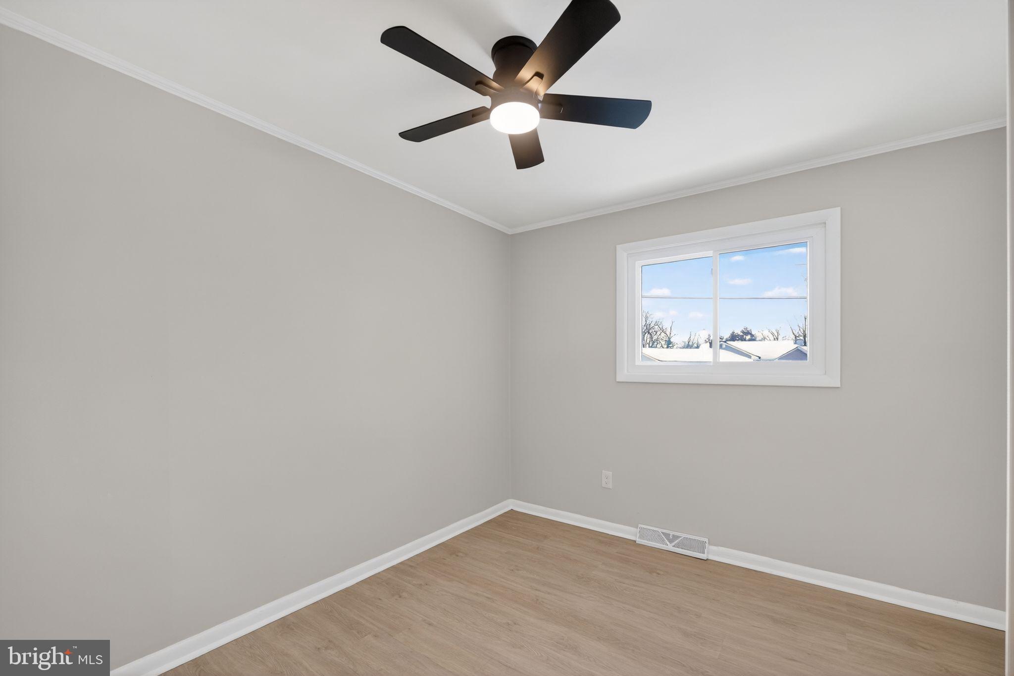 203 Antietam Road Baltimore, MD 21221 - Photo 26 of 33 an empty room with a window and a ceiling fan