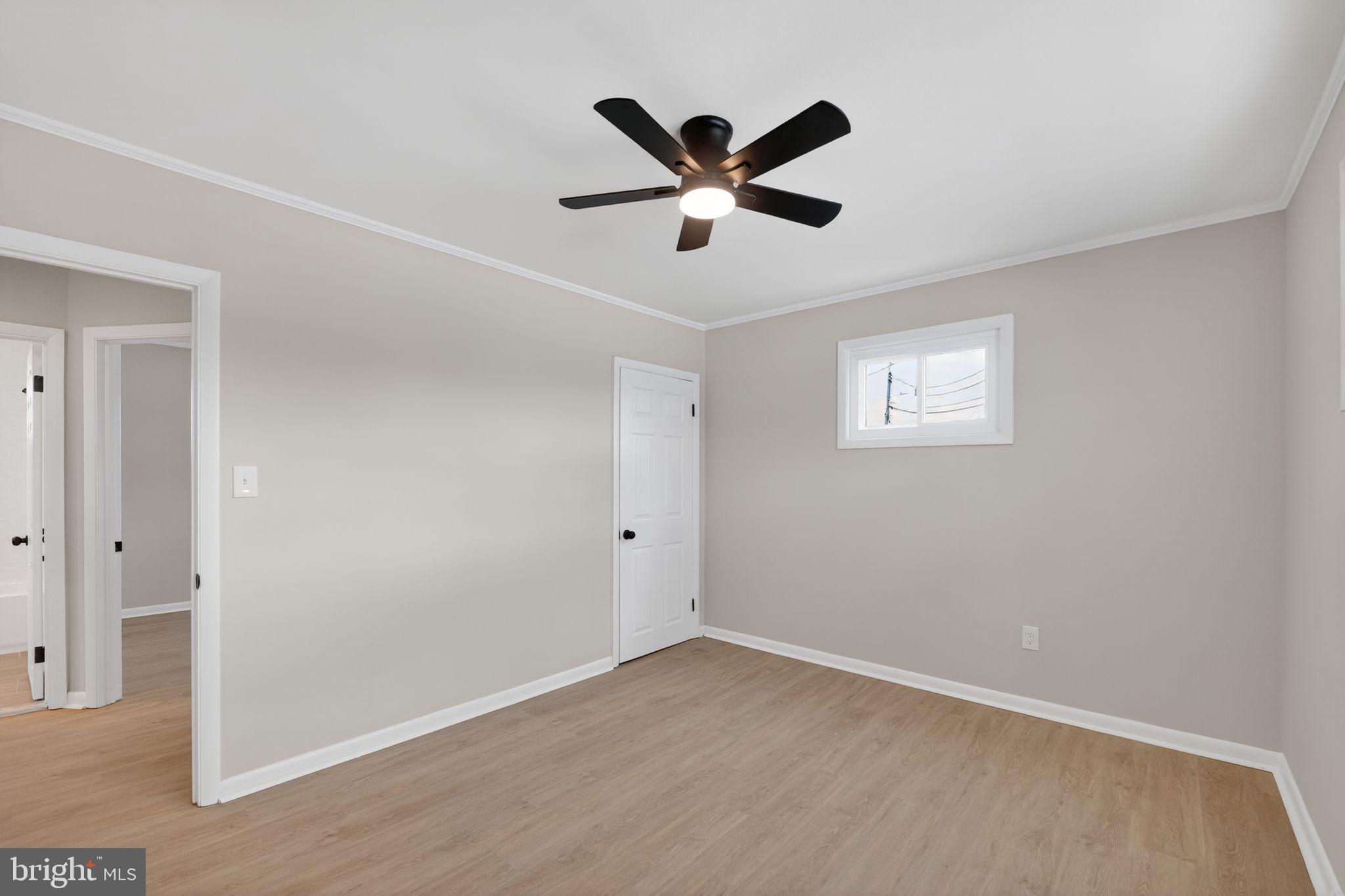 203 Antietam Road Baltimore, MD 21221 - Photo 29 of 33 a view of an empty room with wooden floor and a ceiling fan
