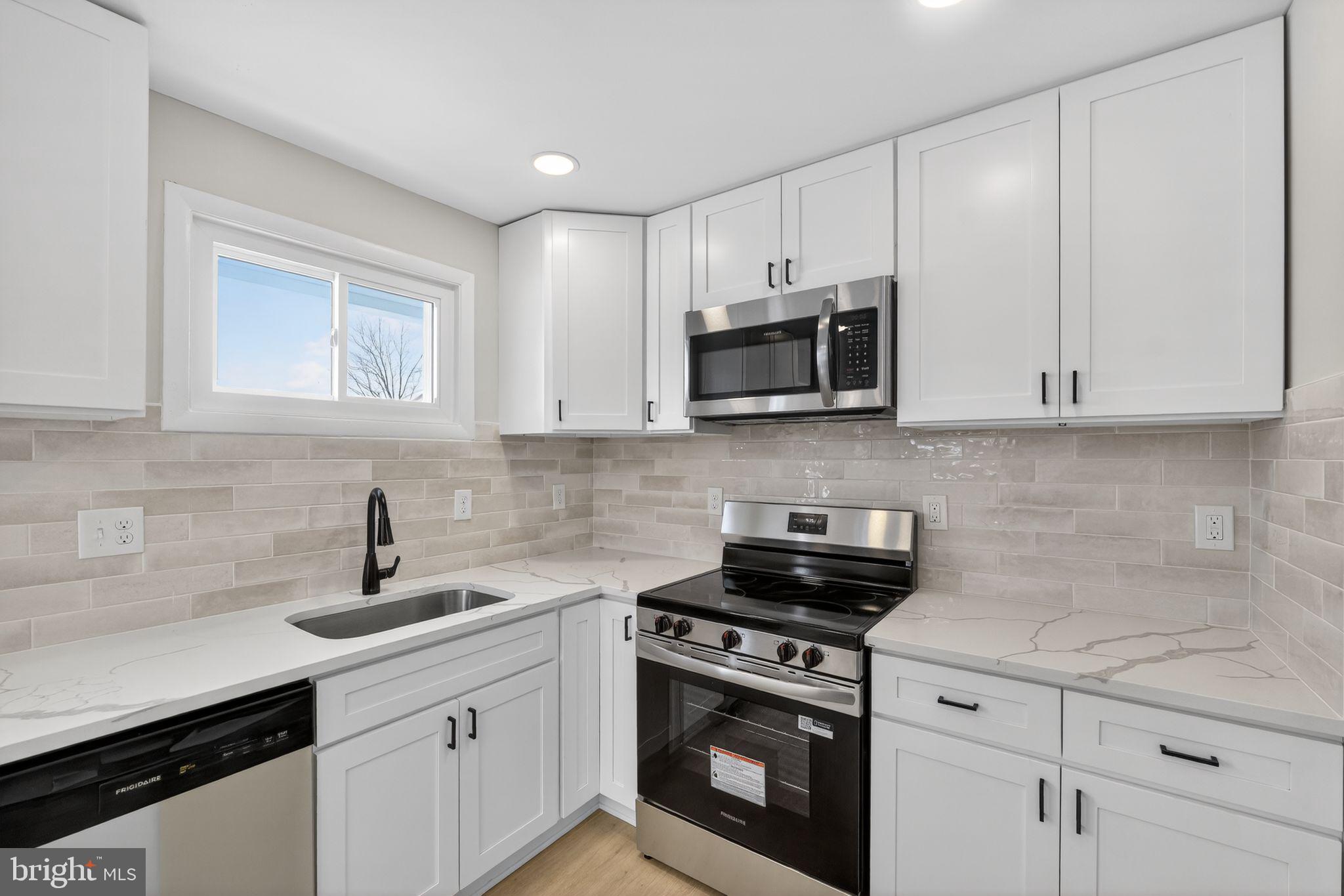 203 Antietam Road Baltimore, MD 21221 - Photo 5 of 33 a kitchen with stainless steel appliances granite countertop grey cabinets a stove a sink and dishwasher